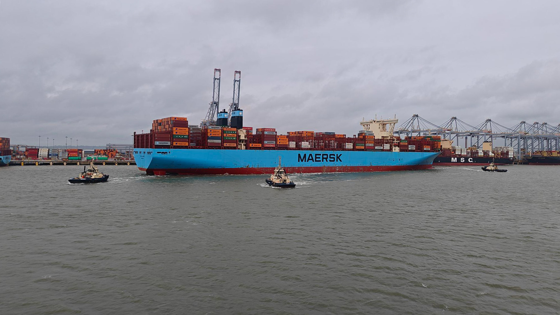 Vessel on the River Thames with three tug boats
