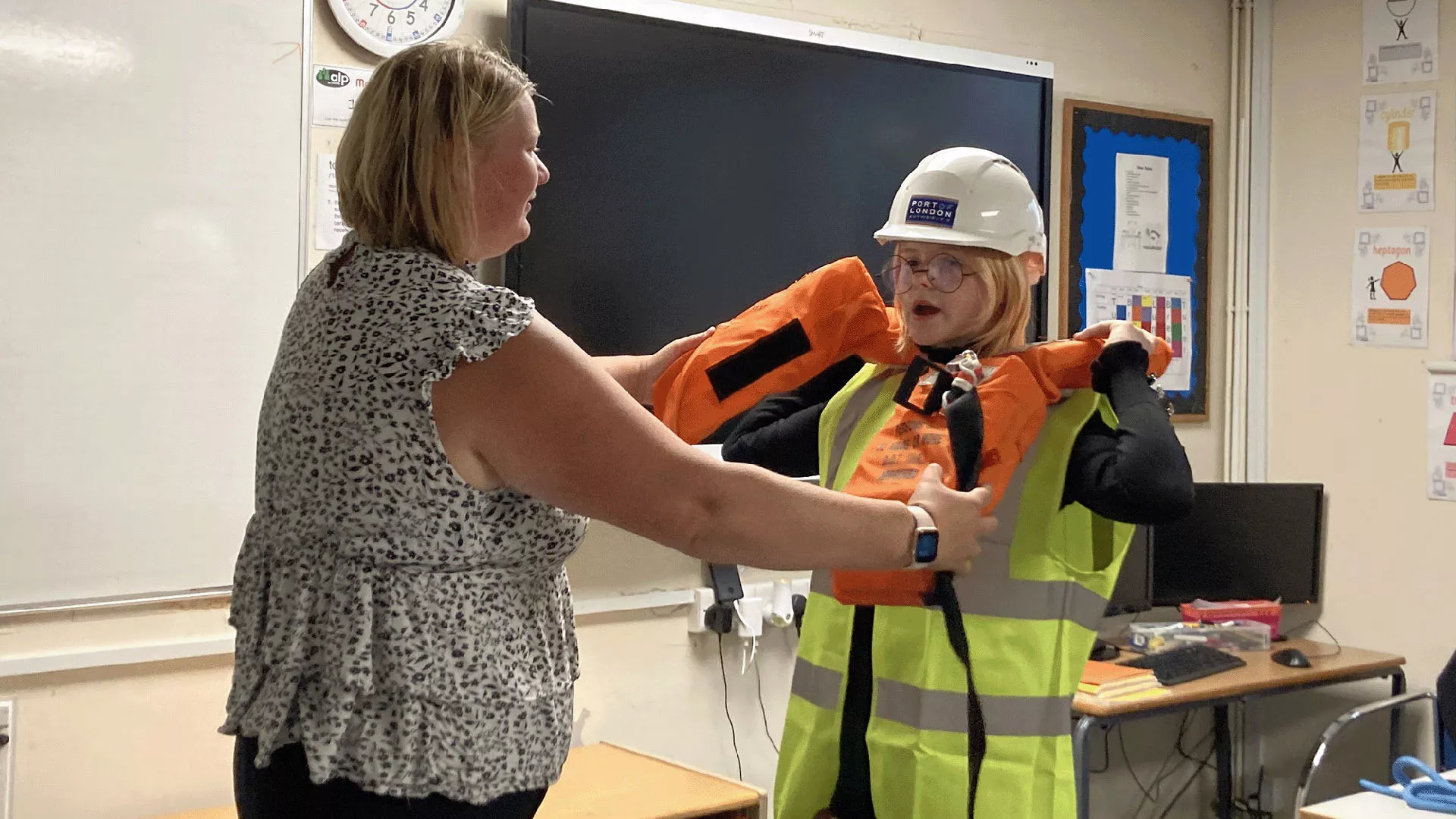 Rachel De Bont with a pupil trying on a PLA hard hat and lifejacket