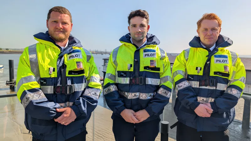 Three new trainee marine pilots with the Thames in the background
